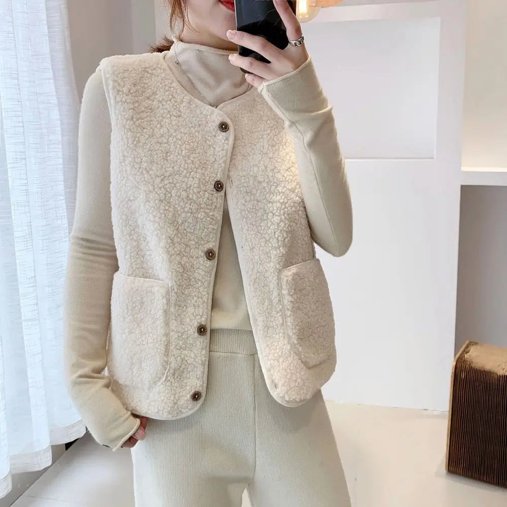 Vrouw draagt een beige fleece wintervest met knopen en zakken, ideaal voor koude seizoenen. Stijlvolle damesmode, warme kleding, casual outfit.